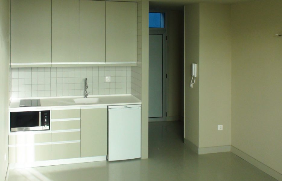 Reconversão de oficina em 6 apartamentos - Vista da entrada de um apartamento e cozinha